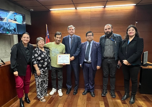 El magistrado Fernando Guzmán, el egresado y su madre, junto al equipo que hizo el seguimiento de su rehabilitación.