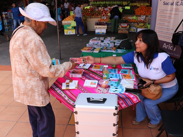La facilitadora intercultural In&eacute;s Flores entreg&oacute; informaci&oacute;n sobre defensa de extranjeros y migrantes en la feria Asoagro de Arica.